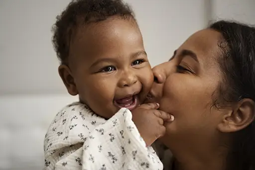 Moms of Menlyn Expo. Mother kissing her smiling baby