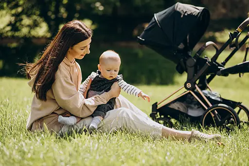 Moms of Menlyn Expo. young mother with her baby and a pram in a park