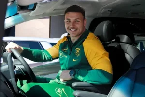 Hyundai Springboks partnership. A Springbok rugby player in a green and yellow uniform smiling while driving a Hyundai vehicle.