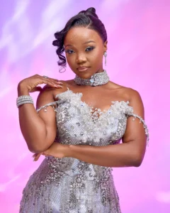 Zanele Potelwa Durban July 2025 in shimmering silver gown, posing confidently in a vibrant studio shoot.