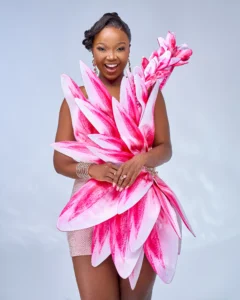 Zanele Potelwa Durban July 2025 in elegant pink floral gown, smiling radiantly at a studio photoshoot.