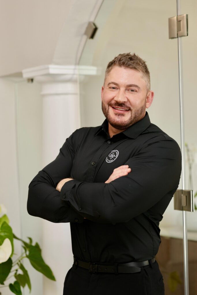 A portrait of Dr JD Erasmus with folded arms, a trusted voice on botulinum toxin safety in South Africa.