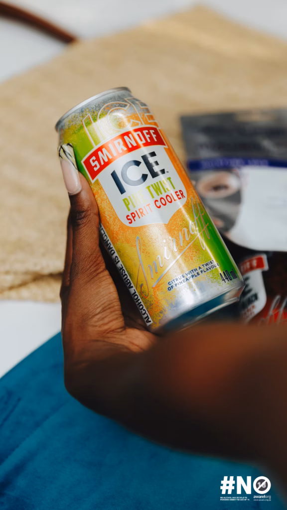 Close-up shot of a hand holding a chilled Smirnoff ICE Pine Twist spirit cooler can, capturing the product detail at the Sun City event.