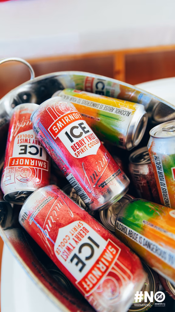 Close-up of hands opening a red branded SMIRNOFF ICE box, showcasing the curated welcome package for guests at the takeover.