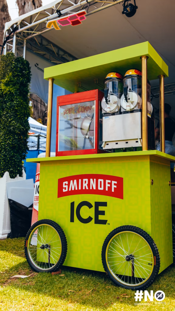 The bright, neon-green branded Smirnoff ICE cart, featuring a popcorn machine and frozen slushie dispensers at the Fon City activation area.