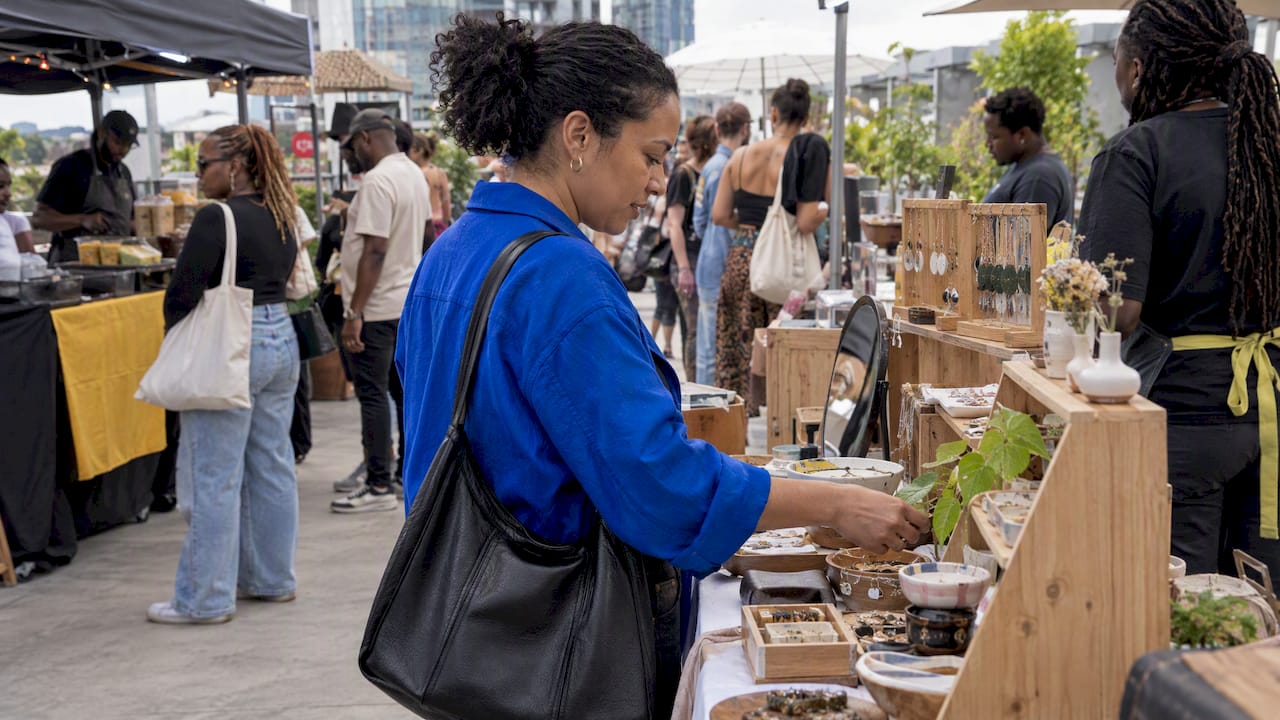 Shopper browsing crafts at Rosebank rooftop market