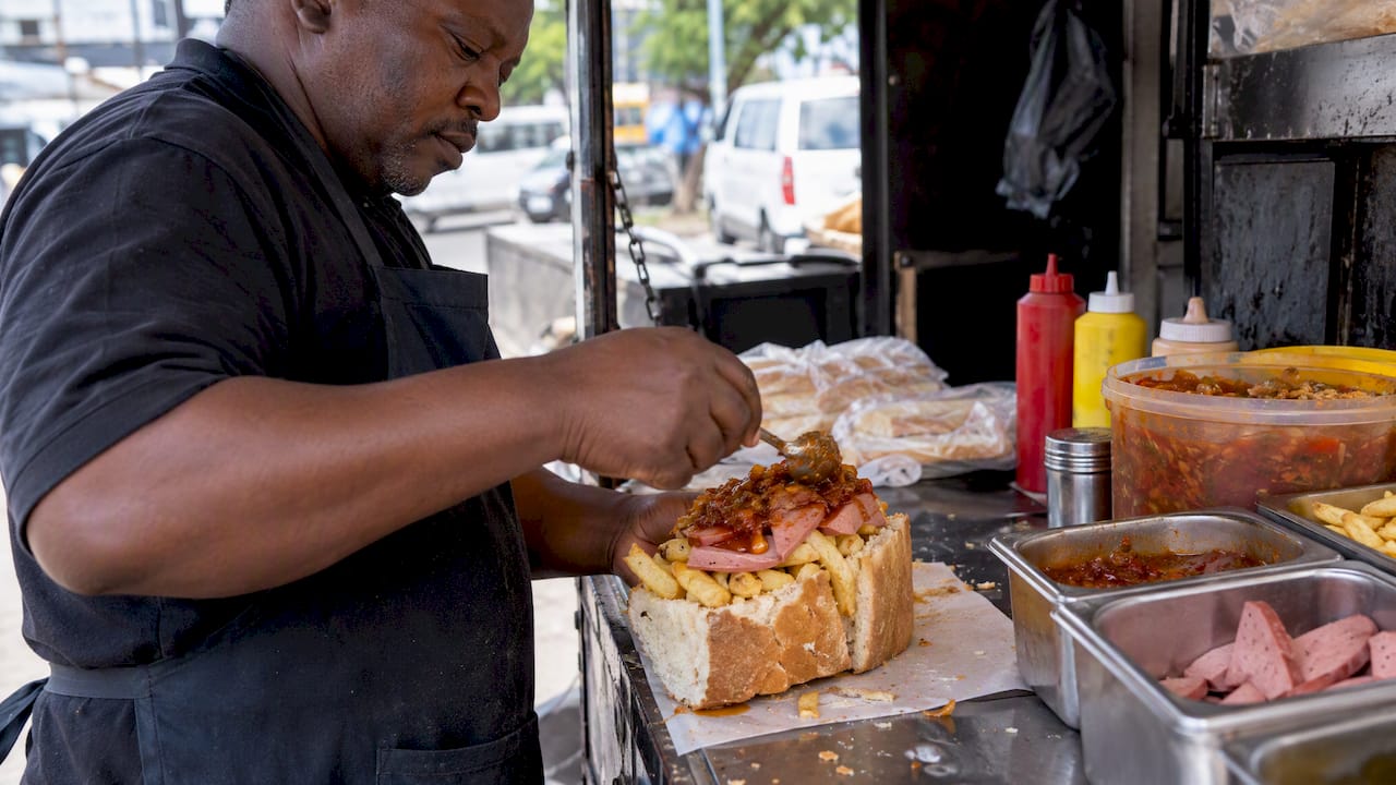 Vendor assembling a filled kota at a street stall