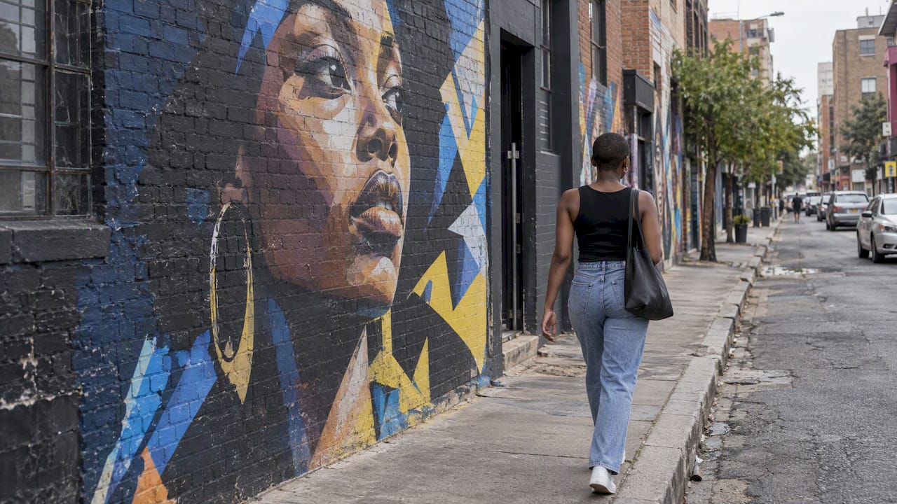 Pedestrian passing a Maboneng street mural