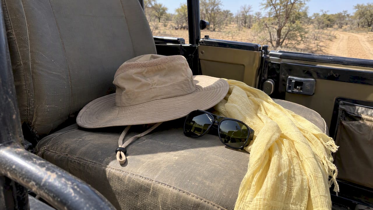 Safari hat scarf and sunglasses on vehicle seat