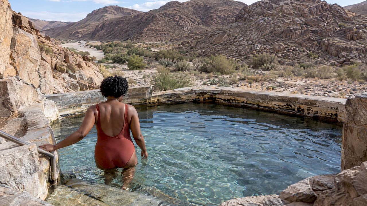 Visitor soaking in a remote desert spring pool